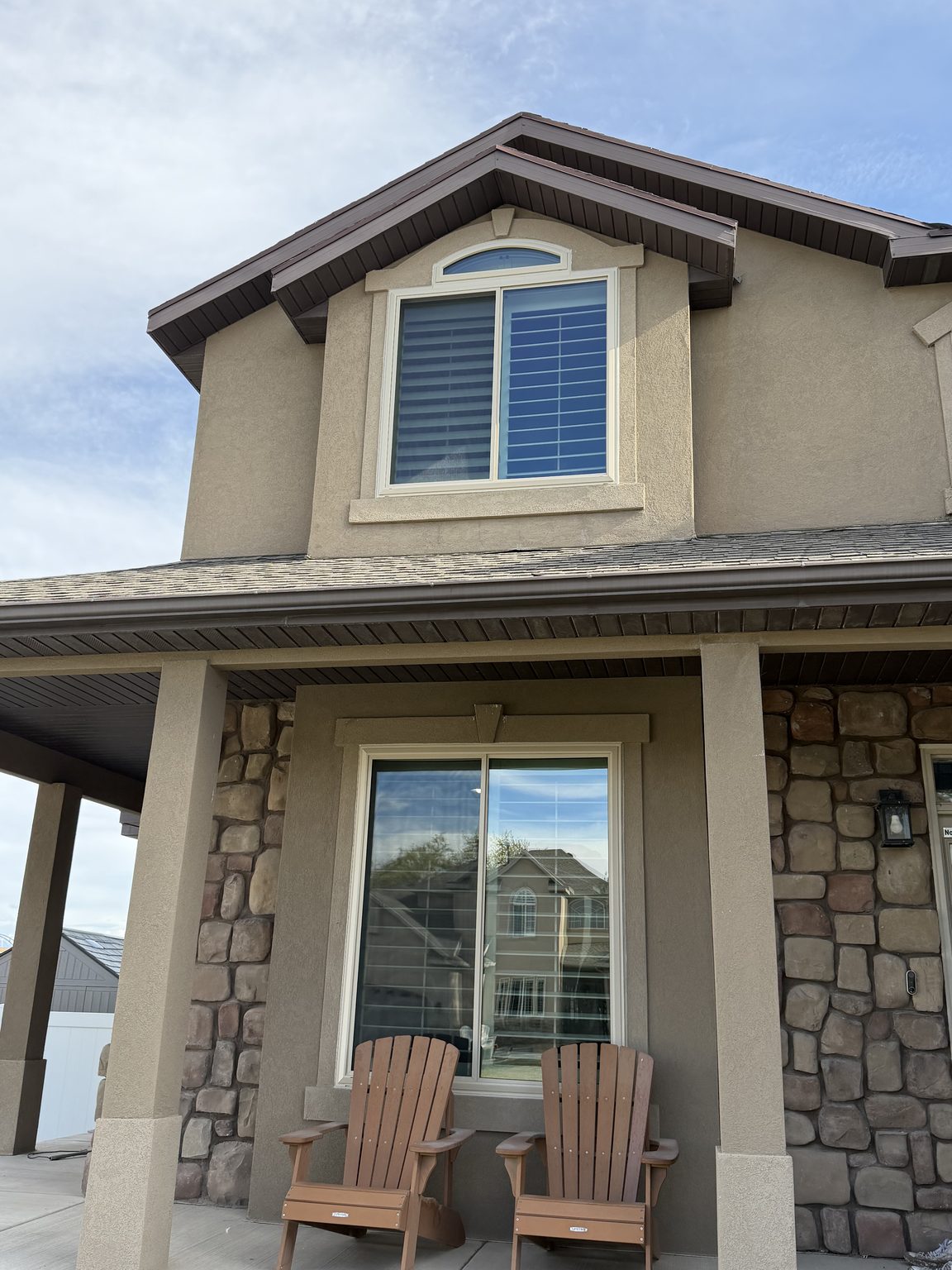 Replacement windows with an arched transom on a stucco and stone elevation