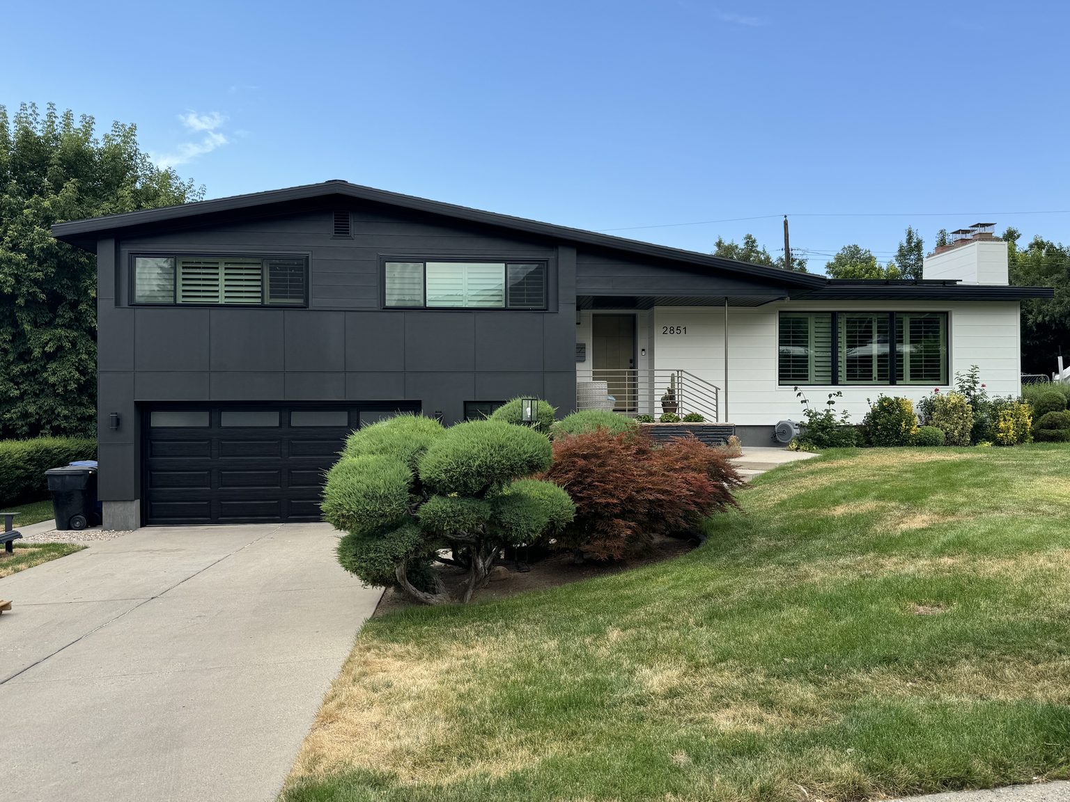 Mid-century home in dark siding after siding and window replacement