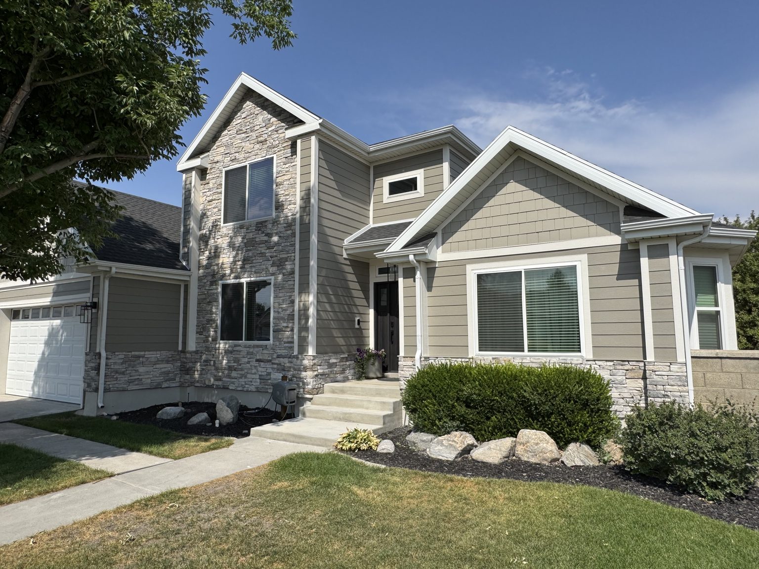 Stone and lap siding elevation with new windows