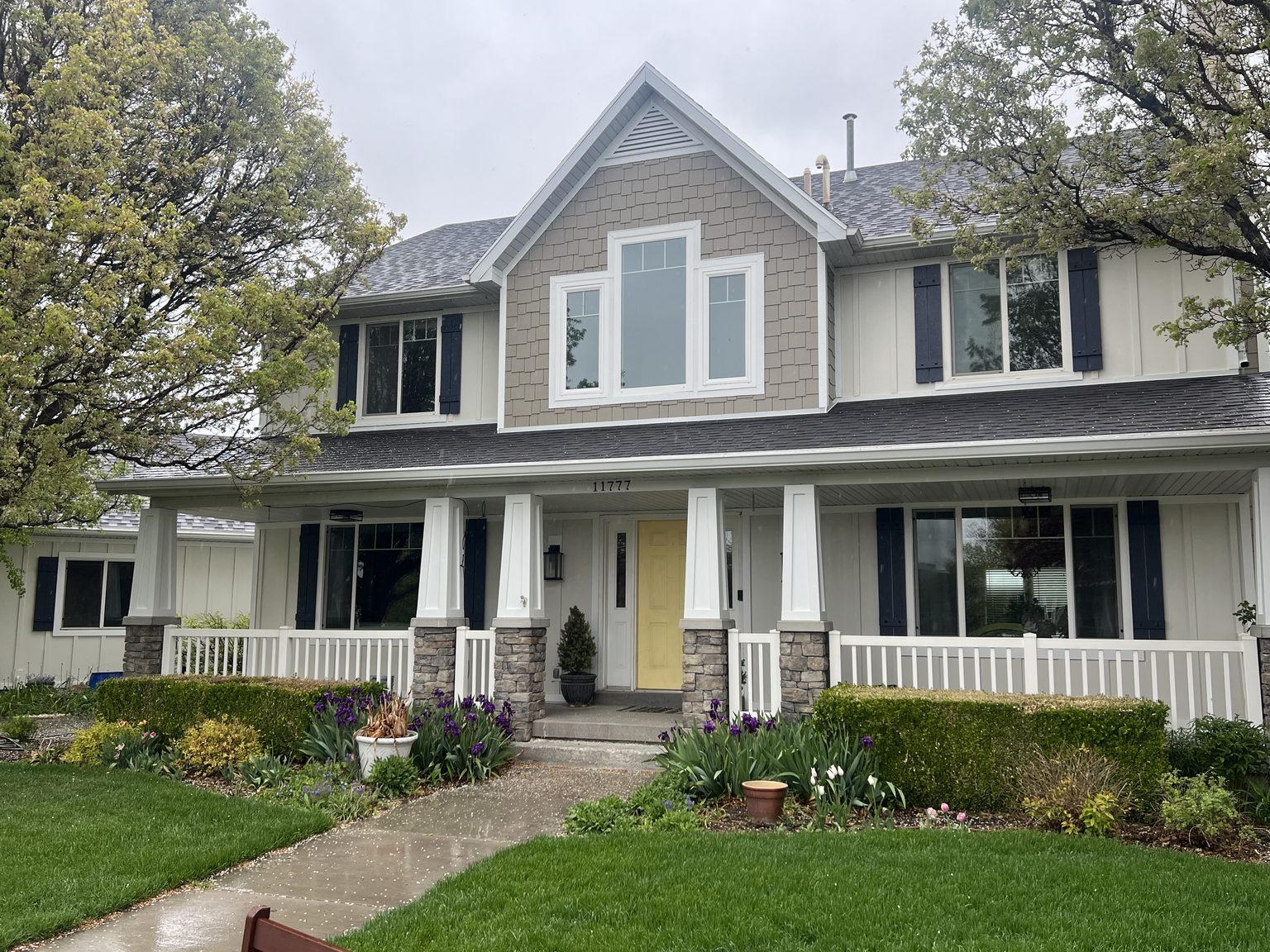 Two-storey home with a covered front porch after window and siding work